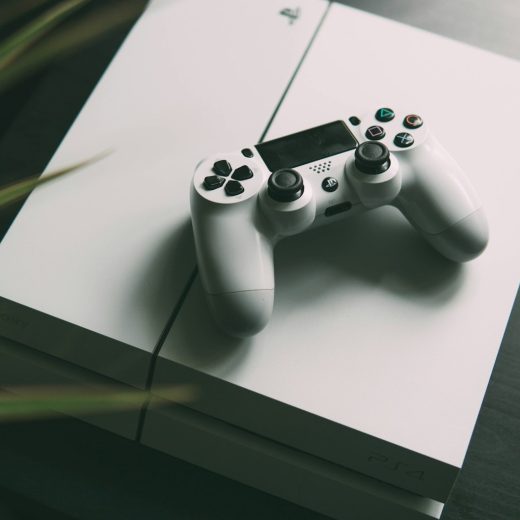 selective focus photography of white Sony PS4 console with wireless controller